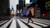 แฟ้ม - ชายข้ามถนนใกล้กับจัตุรัสไทม์สแควร์ที่ว่างเปล่า เมื่อ 23 มี.ค. 2020 ในนิวยอร์ก (เอพี)