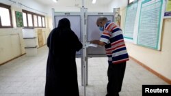 People cast their ballots at a school used as a polling station during the second round of Egypt's parliamentary elections, in Cairo, Egypt, Nov. 7, 2020. 