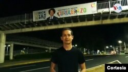 El candidato a diputado Erick Iván Ortiz, posa frente a una pancarta de su campaña política. [Foto: cortesía]