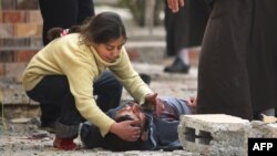 FILE - An Iraqi girl cries over her father's body, who was killed by a mortar shell fired by Islamic State (IS) group jihadists on civilians who were gathered to receive aid, in Al-Risala neighborhood, March 22, 2017.