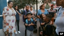 FILE - Damien Salinas, center front, arrives at school on Sept. 7, 2023, in New York. Damien attends his first day of school in New York City after his family emigrated from Ecuador in June. (AP Photo/Andres Kudacki)