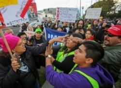 A supporter, right, and an anti-Trump supporter, left, confront each other during a rally, March 13, 2018, in Beverly Hills, California.