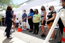 FILE - U.S. Vice President Kamala Harris, left, speaks with workers at a pop-up COVID-19 vaccine clinic outside the Carpenters International Training Center in Las Vegas, Nevada, July 3, 2021.