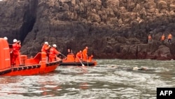 3月14日，中国海警（白色头盔）与金门海巡队（橙色头盔）联合在金门水域搜救落海中国渔民。