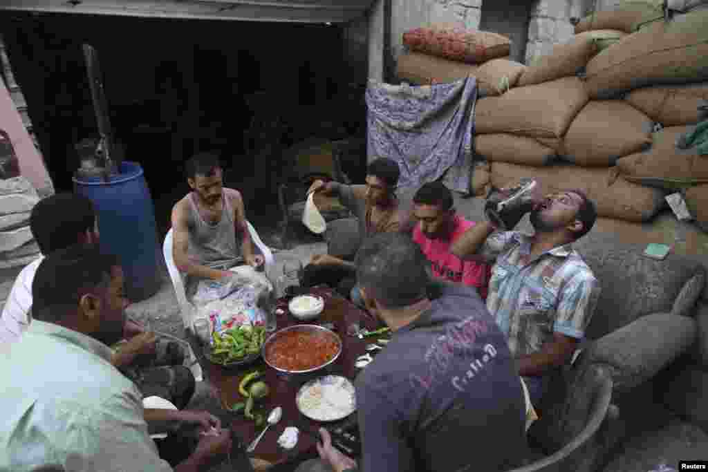 Free Syrian Army fighters eat their iftar meal as they break fast, in Aleppo's Karm al-Jabal neighborhood, July 21, 2013. 