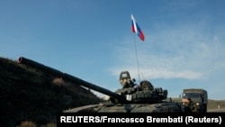 Nagorno Karabah, A service member of the Russian peacekeeping troops stands next to a tank near the border with Armenia