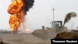 Flames and smoke rise from oil wells inside the Khabbaz oilfield after they were bombed on the outskirts of Kirkuk, Dec 9, 2020. 