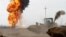 Flames and smoke rise from oil wells inside the Khabbaz oilfield after they were bombed on the outskirts of Kirkuk, Dec 9, 2020. 