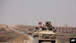 U.S. armored vehicles travel in a joint patrol of the safe zone between Syria and the Turkish border with the Tal Abyad Military Council near Tal Abyad, Syria, Sept. 6, 2019. 