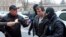 FILE - Marcel Lazar Lehel, 40, is escorted by masked policemen in Bucharest, after being arrested in Arad, west of Bucharest, Romania, Jan. 22, 2014.