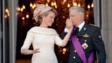 Belgium&#39;s King Philippe, right, kisses the hand of Queen Mathilde as they stand on the balcony of the royal palace in Brussels. Philippe has taken the oath before parliament to become the country&#39;s seventh king after his father Albert abdicated.