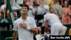 Petenis Serbia, Novak Djokovic tersenyum setelah mengalahkan Rafael Nadal dari Spanyol dalam pertandingan semifinal tunggal putra, Kejuaraan Tenis Wimbledon, di London, Sabtu 14 Juli 2018. (Foto: AP/Ben Curtis)