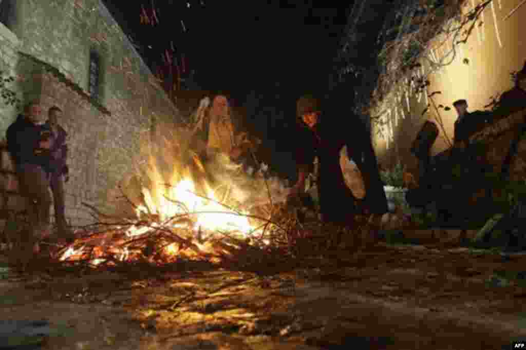Bosnian Serb people gather around a fire of the dried oak branches, the symbol for the Orthodox Christmas eve, during the Christmas Eve ceremony, in front of the Bosnian Orthodox church, in Sarajevo, Friday, Jan. 6, 2012. Bosnian Serbs as Orthodox Christ