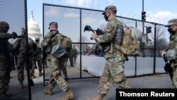 미 연방 의사당에 배치된 주방위군 군인들이 경비용 철책 안으로 진입하고 있다. (자료사진)