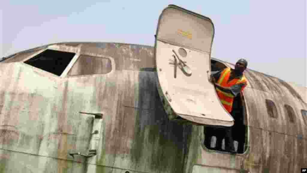 A worker looks out from the fuselage of an abandoned aircraft at Murtala Muhammed International Airport in Lagos, Nigeria.