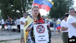 A supporter holds a sign reading '[current Venezuela's President Nicolas Maduro] murderer of Venezuela', upon the arrival of Edmundo Gonzalez Urrutia at Madrid's Torrejon de Ardoz military airport, Sept. 8, 2024.