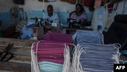 FILE - Tailors make face masks at the Tayamba Tailoring shop, which has embarked in the business of producing face masks intended to protect against the COVID-19 coronavirus, in Lilongwe, Malawi, May 4, 2020.