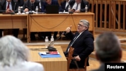 FILE - Leader of Greece's far-right Golden Dawn party Nikos Mihaloliakos testifies during the trial of members and leaders of the party in a Court in Athens, Greece, Nov. 6, 2019.