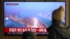 People watch a television screen showing a news broadcast with file footage of a North Korean missile test, at a train station in Seoul on Jan. 14, 2025.