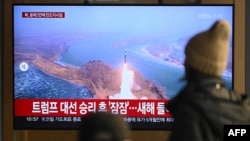 People watch a television screen showing a news broadcast with file footage of a North Korean missile test, at a train station in Seoul on Jan. 14, 2025.