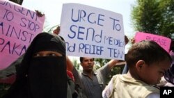 An ethnic Rohingya refugee holds up a poster during a demonstration calling for the end to the sectarian violence in Burma, in Medan, North Sumatra, Indonesia, Wednesday, June 13, 2012. 