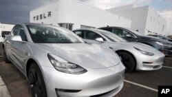 In this July 8, 2018, file photo, 2018 Model 3 sedans sit on display outside a Tesla showroom in Littleton, Colo. (AP Photo/David Zalubowski, File)