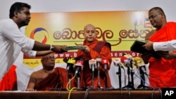 Myanmar’s radical Buddhist monk Ashin Wirathu, center, exchanges copies of a three-point agreement with the officials of Sri Lanka's Bodu Bala Sena or Buddhist Power Force during a media briefing in Colombo, Sri Lanka, Sept. 30, 2014. 