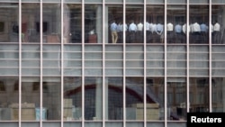 FILE - Staff stand in a meeting room at Lehman Brothers offices in the financial district of Canary Wharf in London, September 2008.