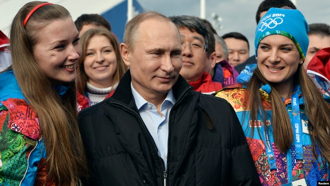 Russian President Vladimir Putin (C) and Olympic Village Mayor Elena Isinbaeva (R) visit the Coastal Cluster Olympic Village ahead of the Sochi 2014 Winter Olympics at the Athletes Village in Sochi, Feb. 5, 2014. 