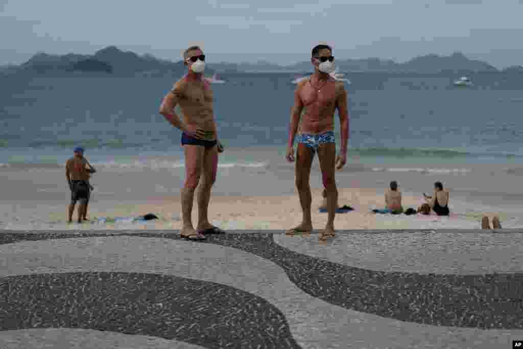 브라질 리우데자네이루의 코파카바나 해변에서 두 남성이 마스크를 착용하고 있다. 