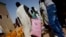 FILE - A man walks away with a bag of rice at a food distribution center run by the Spanish NGO  Accion Contra el Hambre (Action Against Hunger) in Tarenguel, Mauritania, May 30, 2012.