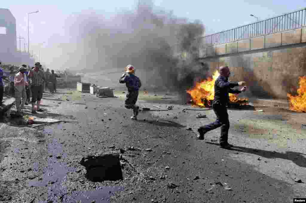 A police officer reacts at the scene of a car bomb attack in Nasiriyah, Iraq, June 16, 2013. 