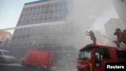 Firefighters put out a fire at the Duroy hotel following a bomb attack, in Raouche, in western Beirut, June 25, 2014.