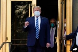 FILE - President Donald Trump walks out of Walter Reed National Military Medical Center to return to the White House after receiving treatments for COVID-19 in Bethesda, Maryland, Oct. 5, 2020.