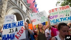 Demonstrators protest outside the Trump International Hotel in Washington, June 28, 2017, as President Donald Trump is attending a fundraiser at the hotel. 