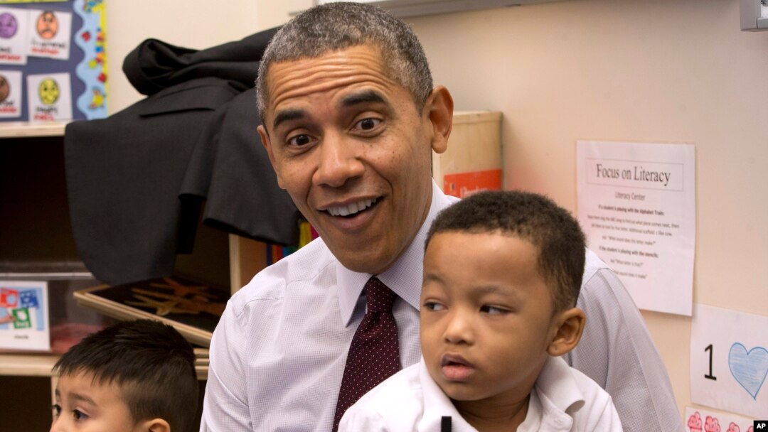 President Barack Obama sits with Marcus Wesby and other preschool student during his visit to Powell Elementary School in the Petworth neighborhood of Washington, March 4, 2014. 