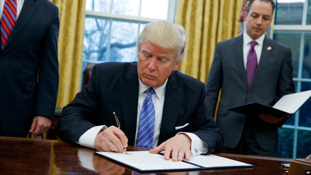 Presiden AS Donald Trump saat menandatangani instruksi untuk menarik Amerika dari perjanjian perdagangan Pasifik, TPP, Januari 2017. (AP/Evan Vucci)