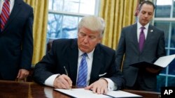 Donald Trump signe l'acte de retrait des Etats-Unis du traité de libre-échange transpacifique (TPP), Washington, le 23 janvier 2017