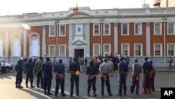 FILE: Police gather outside the Constitutional Court after the court upheld Zimbabwean President Emmerson Mnangagwa' s narrow victory in Harare, Friday, August, 24, 2018. Zimbabwe's constitutional court on Friday unanimously upheld President Emmerson Mnangagwa's narrow victory.