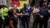 ARCHIVO - Una mujer discute con un oficial de policía durante una protesta exigiendo un aumento del salario mínimo y la libertad de los sindicalistas encarcelados en Caracas, Venezuela, el jueves 3 de agosto de 2023.