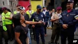 ARCHIVO - Una mujer discute con un oficial de policía durante una protesta exigiendo un aumento del salario mínimo y la libertad de los sindicalistas encarcelados en Caracas, Venezuela, el jueves 3 de agosto de 2023.