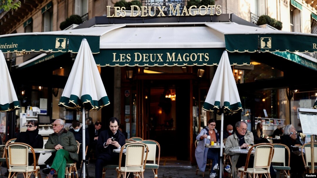 Pelanggan duduk di teras kafe dan restoran Les Deux Magots di Paris yang dibuka kembali setelah tutup selama berbulan-bulan di tengah pandemi COVID-19 di Perancis, 19 Mei 2021. (REUTERS / Christian Hartmann)