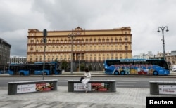 FILE - A woman uses her mobile phone in front of the Federal Security Service (FSB) building on Lubyanka Square in Moscow, Russia, June 24, 2023.