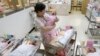 FILE - A nurse looks after babies inside the maternity ward of a hospital in Taipei, Oct. 25, 2011. 