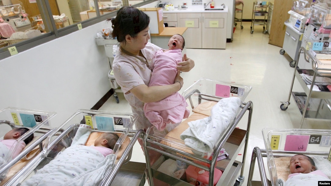 FILE - A nurse looks after babies inside the maternity ward of a hospital in Taipei, Oct. 25, 2011. 