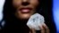 A model displays a large diamond at Sotheby's in New York, May 4, 2016. A 3-billion-year-old diamond the size of a tennis ball — the largest discovered in over a century — could sell for more than $70 million, auctioneer Sotheby's said Wednesday.