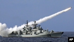 In this file photo, a Chinese warship launches a missile during a live-ammunition military drill held last year in the South China Sea. 