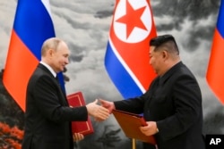 FILE - FILE - Russian President Vladimir Putin and North Korean leader Kim Jong Un exchange documents during a signing ceremony for a new partnership in Pyongyang, North Korea, June 19, 2024.