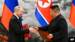 Tổng thống Nga Vladimir Putin (trái) và nhà lãnh đạo Triều Tiên Kim Jong Un trao đổi tài liệu trong buổi lễ ký kết quan hệ đối tác mới tại Bình Nhưỡng, Triều Tiên, ngày 19/6/2024.