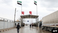 FILE - People cross from Turkey into northern Syria at the Bab al-Salam border crossing, March 13, 2020. 